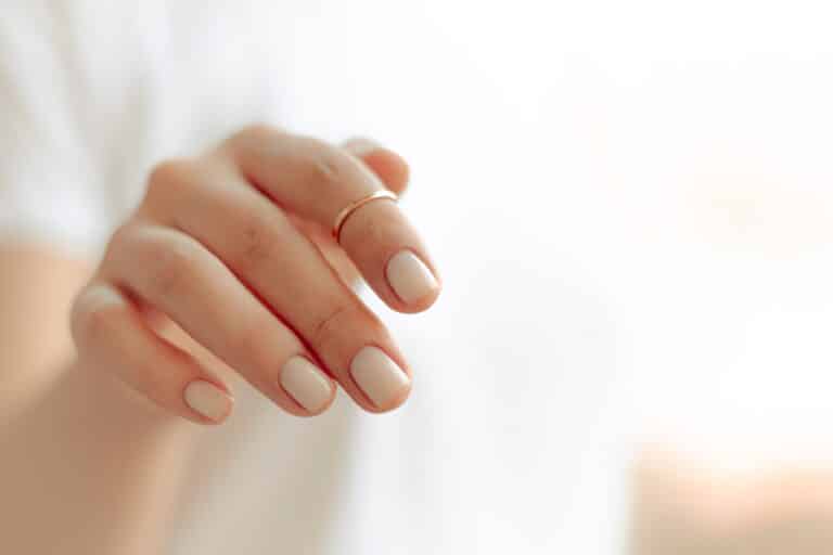 persons hand with white manicure